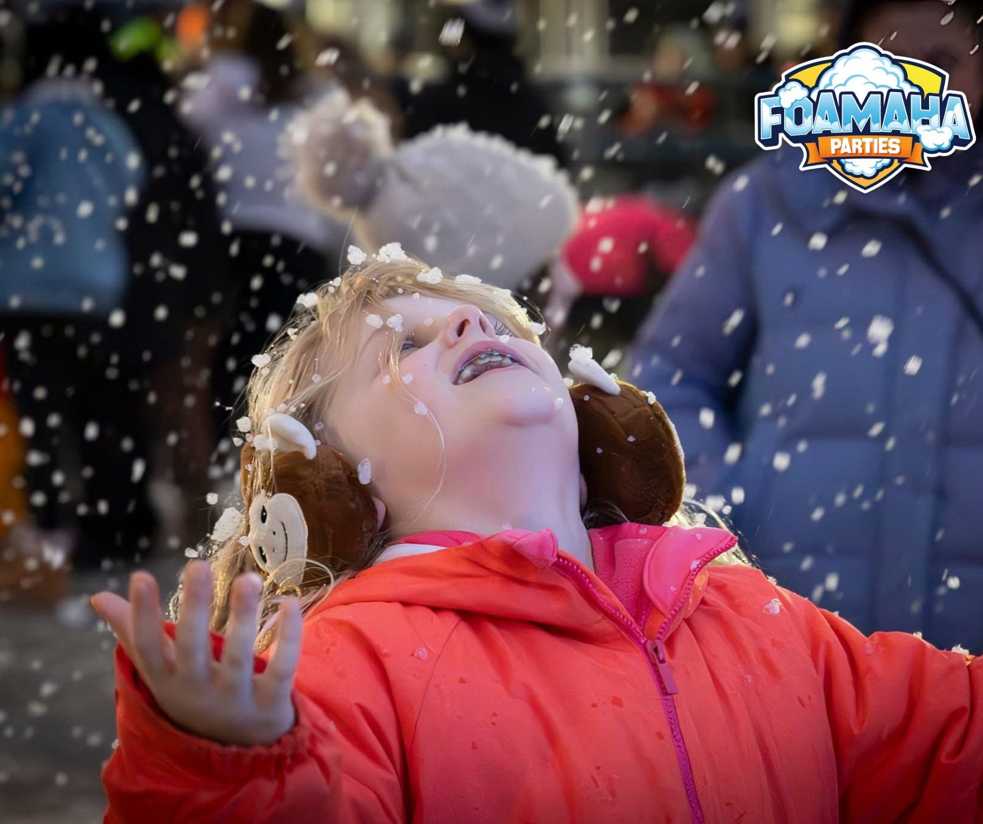 Girl smiling up at falling snow at a Foamaha snow event